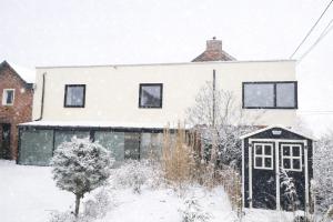 a white house with snow on the ground at Le repaire du raton laveur in Rance