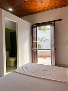 a bedroom with a bed and a bathroom with a window at Casa vacacional SAMUEL in Honda