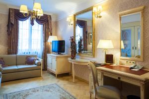 ein Hotelzimmer mit Schreibtisch, Fernseher und Sofa in der Unterkunft Hotel Branicki in Białystok + 102 Fotos
