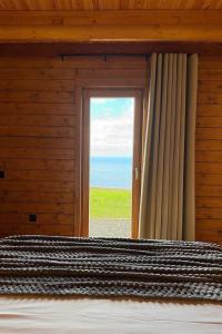 a bedroom with a window with a view of the ocean at Sunset Eco Shelter 1 in Ponta do Pargo