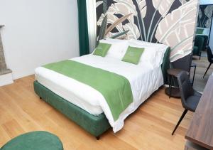 a bed with green and white sheets and pillows at Boutique Hotel Magenta in Magenta