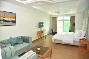 a hotel room with a bed and a couch at Scenic Hotel Near Earthquake Memorial Bridge,203 in Muzaffarabad +20 photos