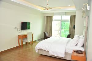 a bedroom with a bed and a desk and a television at Scenic Hotel Near Earthquake Memorial Bridge,203 in Muzaffarabad