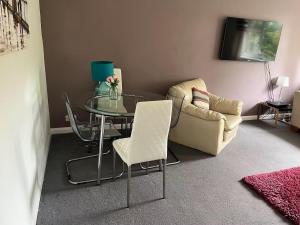 a dining room with a glass table and a chair at A Home from Home -2 Bed Flat & Free Driveway Parking in Ascot +45 photos
