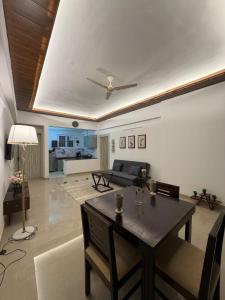 a living room with a table and a couch at Shiva Stays - Make yourself at home in Lucknow