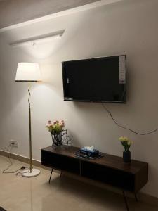 a living room with a television on a wall at Shiva Stays - Make yourself at home in Lucknow