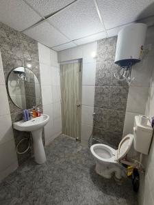 a bathroom with a toilet and a sink and a mirror at Shiva Stays - Make yourself at home in Lucknow +11 photos