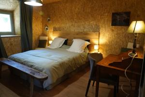 a bedroom with a bed and a table and a desk at Plantes et sabots in Barriac-les-Bosquets