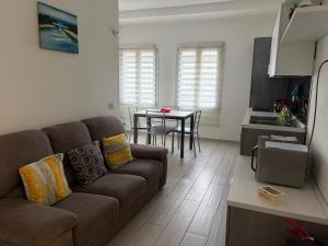 a living room with a brown couch and a table at Apartment Orio Volta in Orio al Serio