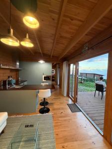 a room with a kitchen and a living room with a table at Sunset Eco Shelter 5 in Ponta do Pargo