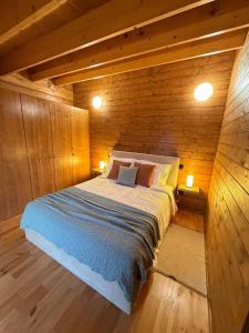 a bedroom with a bed in a wooden cabin at Sunset Eco Shelter 5 in Ponta do Pargo