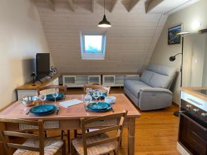 a living room with a table with chairs and a couch at Les mouettes rieuses in Telgruc-sur-Mer