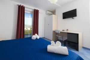 a bedroom with a blue bed with a desk and a monitor at Belvedere in Procida
