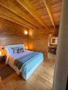 a bedroom with a large bed in a wooden cabin at Sunset Eco Shelter 2 in Ponta do Pargo