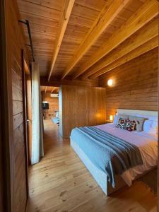 a bedroom with a large bed in a wooden cabin at Sunset Eco Shelter 2 in Ponta do Pargo