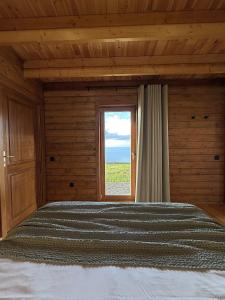 a bedroom with a large bed with a window at Sunset Eco Shelter 3 in Ponta do Pargo