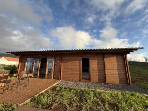 a small house on a wooden deck with a table at Sunset Eco Shelter 3 in Ponta do Pargo