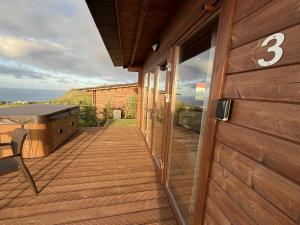 a house with a deck with a number on it at Sunset Eco Shelter 3 in Ponta do Pargo +7 photos