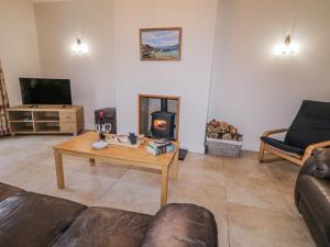 a living room with a coffee table and a fireplace at Foyle Cottage in Strabane