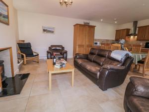 a living room with leather couches and a coffee table at Foyle Cottage in Strabane