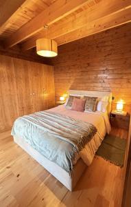 a bedroom with a large bed with wooden walls at Sunset Eco Shelter 4 in Ponta do Pargo +19 photos