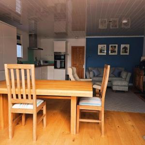 a wooden table and chairs in a living room at Dinky Daze Norfolk Broads in Brundall