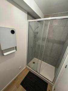 a shower with a glass door in a bathroom at Logement 11 parking gratuit in Poitiers +10 photos
