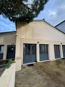 a large building with gray doors and windows at Logement 11 parking gratuit in Poitiers