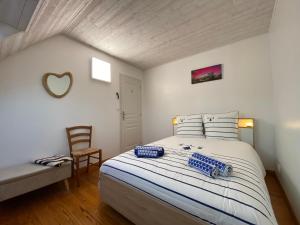 a bedroom with a large white bed with a chair at Les mouettes rieuses in Telgruc-sur-Mer