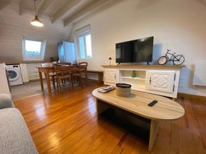a living room with a table and a tv at Les mouettes rieuses in Telgruc-sur-Mer