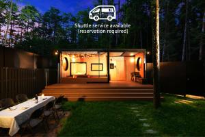 a tiny house with a table and chairs in a yard at Fuji Fumoto Forest Onsen ふじ ふもとの森温泉 in Fujikawaguchiko