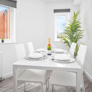 a white dining room with a white table and chairs at Modern Two Bed Apartment - Sleeps 3 - Parking - Netflix 50C in Netherton