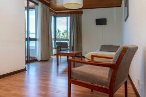 a room with a bed and a chair and a table at Flag Hotel Madeira - Ribeira Brava in Ribeira Brava