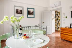 ein Esszimmer mit einem weißen Tisch und einer Flasche Wein in der Unterkunft PianPieve Family Apartments vicino Assisi in Assisi