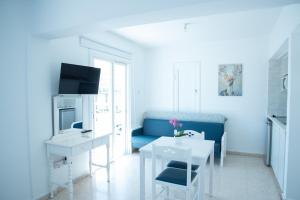 a living room with a blue couch and a table at Flisvos Beach Apartments in Protaras