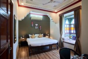 a bedroom with a bed and a window at Elysium Retreat- The Heritage Haveli in Udaipur