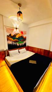 a bedroom with a bed with a painting on the wall at Bawli Treehouse Duplex, Jibhi in Jibhi