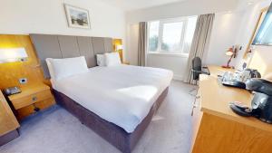 a hotel room with a large bed and a desk at Holiday Inn Kenilworth - Warwick by IHG in Kenilworth
