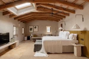 a bedroom with a large bed and a living room at Hotel Vestige Binidufà in Isla de Menorca