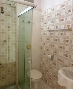 a bathroom with a toilet and a glass shower at Grande Hotel Torres in Torres