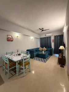 a living room with a table and a blue couch at Elegant 1BHK at Shiva Stays, behind lulu mall in Lucknow