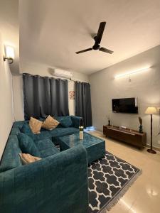 a living room with a green couch and a ceiling fan at Elegant 1BHK at Shiva Stays, behind lulu mall in Lucknow