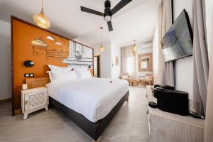 a bedroom with a large white bed and a flat screen tv at Villa de Luxe avec Piscine privée chauffée-3 Chambres-Sud Sauvage in Petite Île