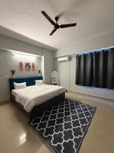 a bedroom with a bed with a ceiling fan and a rug at Elegant 1BHK at Shiva Stays, behind lulu mall in Lucknow