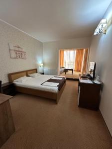 a bedroom with a bed and a desk with a laptop at Hotel Hanul de la Rascruce in Arad