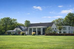 a house with a large lawn in front of it at De Slaapfabriek Teuge Apeldoorn in Teuge