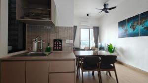 a kitchen with a sink and a counter with two chairs at The Grand SS15 Sunway 4Pax 2BRs City View - Free WiFi, Infinity Pool & Gym in Subang Jaya