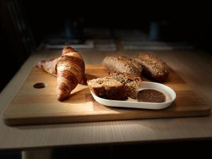 a wooden cutting board with bread and pastries on it at Casa Carlini in Getxo +41 photos