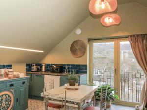 a kitchen with green cabinets and a table and a window at Golden Valley View in Stroud