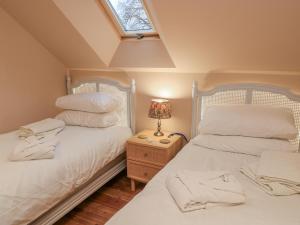 two twin beds in a room with a window at Golden Valley View in Stroud